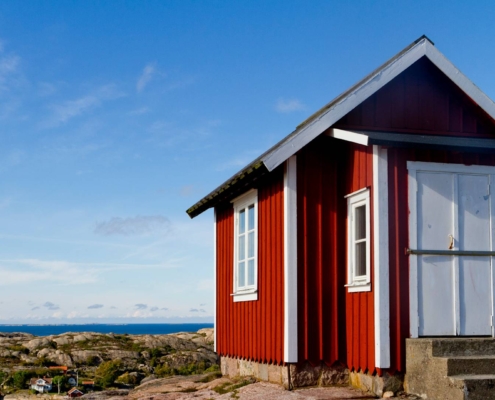 Casa tradicional sueca roja frente al mar en la costa de Bohuslän, Suecia