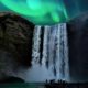 Auroras boreales sobre la cascada Skógafoss en paisaje nocturno de Islandia