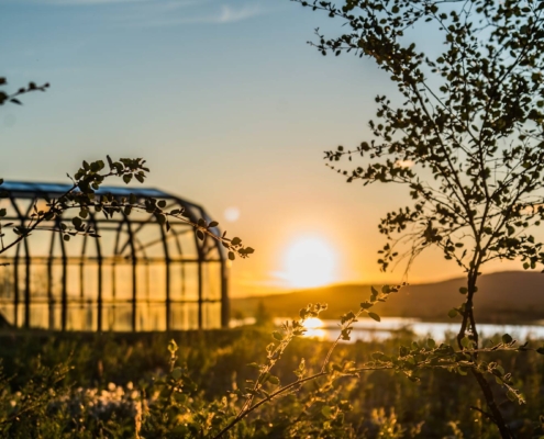 Paisaje urbano de Rovaniemi iluminado por el sol de medianoche junto a un puente y el río