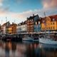 Nyhavn al atardecer con casas de colores y veleros amarrados en el canal de Copenhague
