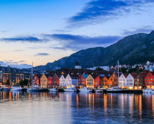 Vista panorámica de Bergen con Bryggen iluminado y montañas de fondo, imagen del viaje Capitales Escandinavas y Fiordos