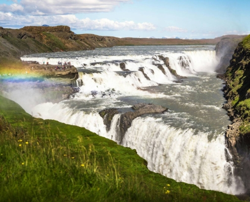 Cascada Gullfoss con doble salto y cañón rocoso cubierto de vegetación en Islandia