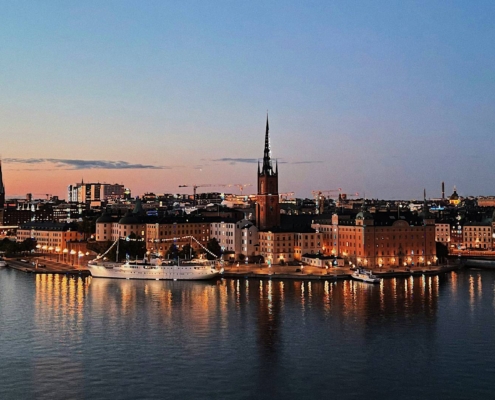 Puerto histórico de Estocolmo al atardecer con edificios iluminados reflejados en el agua