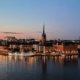 Puerto histórico de Estocolmo al atardecer con edificios iluminados reflejados en el agua