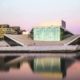 Ópera de Oslo al atardecer con fachada moderna reflejada en el agua del puerto