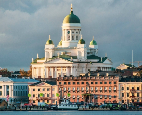 Catedral de Helsinki iluminada al atardecer vista desde el puerto con edificios históricos