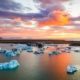 Icebergs flotando en laguna glaciar bajo cielo rosado al atardecer en Islandia