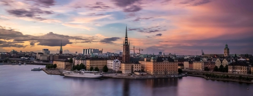 Puerto de Estocolmo al atardecer con edificios históricos y reflejos de luz sobre el agua