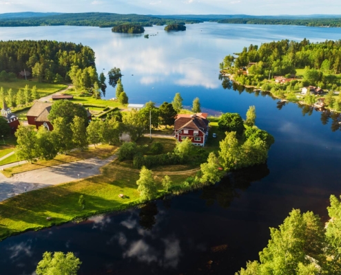 Mansión típica sueca junto a un lago en Dalarna, rodeada de bosques verdes en verano