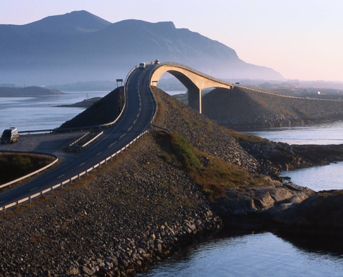 Carretera del Atlántico serpenteando entre islas y mar al atardecer, Noruega