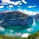 Vista aérea del fiordo de Geiranger con montañas, agua turquesa y cruceros, Noruega