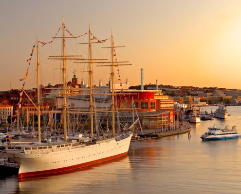 Vista del archipiélago de Gotemburgo con embarcaciones y la ciudad iluminada por la puesta de sol