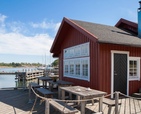 Casa de madera roja junto al mar en el archipiélago de Åland con cielo despejado