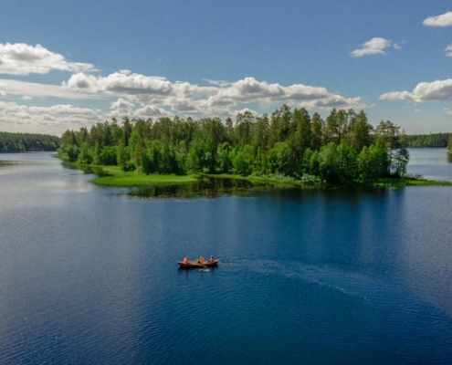 Lago Saimaa rodeado de bosque verde con pequeñas islas y agua calmada en Finlandia