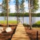 Terraza de madera junto a lago rodeado de pinos y agua tranquila en Finlandia