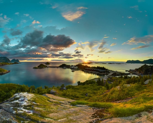 Paisaje costero de Senja con montañas y mar iluminados por el sol de medianoche, Noruega