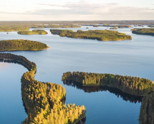 Lago rodeado de islas y bosque boreal con agua en calma en Finlandia