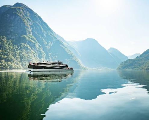 Barco eléctrico navegando por el Nærøyfjord entre montañas y aguas tranquilas, Noruega