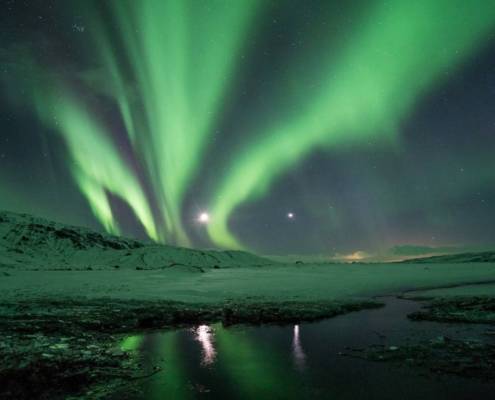 Auroras boreales sobre paisaje nevado nocturno en Islandia