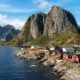 Casas rojas de pescadores en Reine junto al mar y montañas escarpadas en Lofoten, Noruega