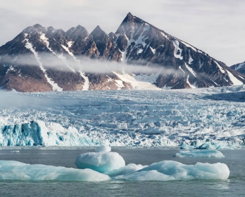 Glaciares y bloques de hielo flotando frente a montañas árticas en Spitsbergen, Svalbard