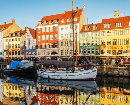 Canal de Nyhavn con casas de colores y barcos reflejados en el agua en Copenhague