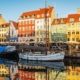 Canal de Nyhavn con casas de colores y barcos reflejados en el agua en Copenhague