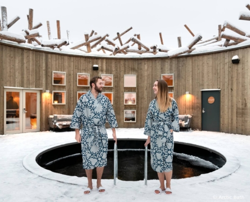 Huéspedes disfrutando del baño helado en Arctic Bath durante el invierno en Laponia sueca