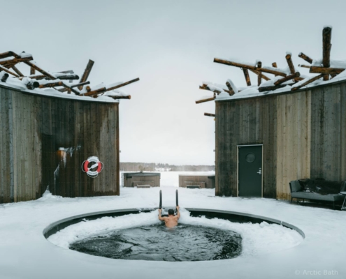 Baño exterior de agua helada junto a cabañas de Arctic Bath en invierno, Laponia sueca