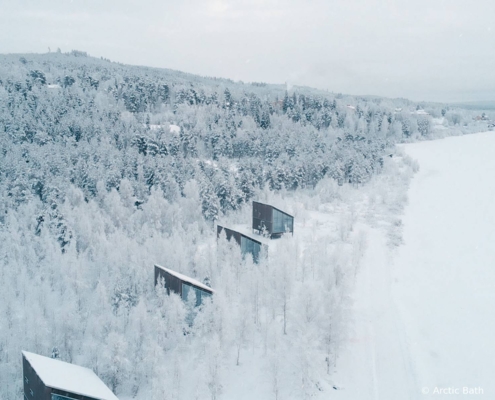 Cabañas de Arctic Bath integradas en el bosque nevado de Laponia sueca