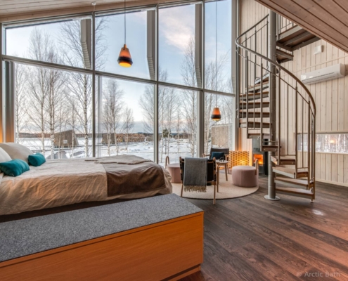 Habitación de Arctic Bath con diseño nórdico, grandes ventanales y vistas al paisaje invernal
