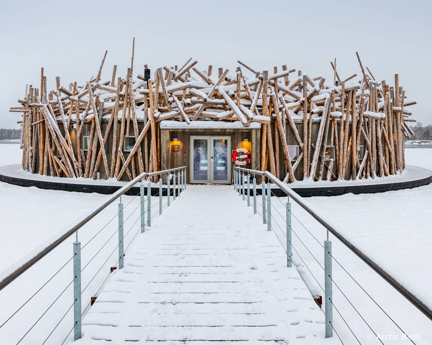 Hotel Arctic Bath en Laponia sueca durante el día, pasarela de acceso y entorno nevado