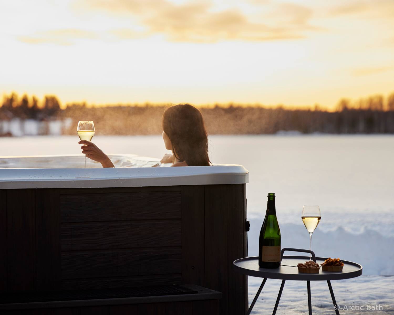 Jacuzzi exterior de Arctic Bath rodeado de nieve en el entorno natural de Laponia sueca