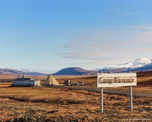 Camp Barentz en Svalbard con tiendas árticas y el paisaje polar al fondo