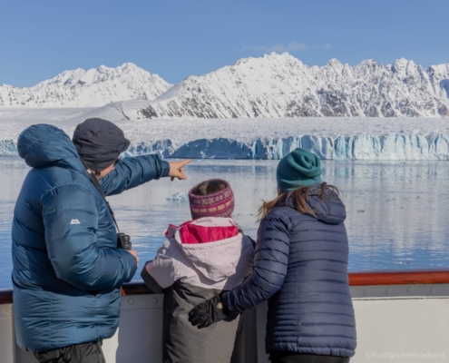 Familia observa glaciares desde la cubierta del MS Serenissima durante la navegación por Svalbard.