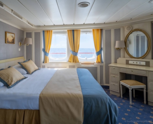 Suite del MS Serenissima con cama doble y ventanales al paisaje polar