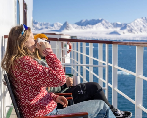 Pasajeros sentados en cubierta del MS Serenissima con vistas al paisaje de Svalbard