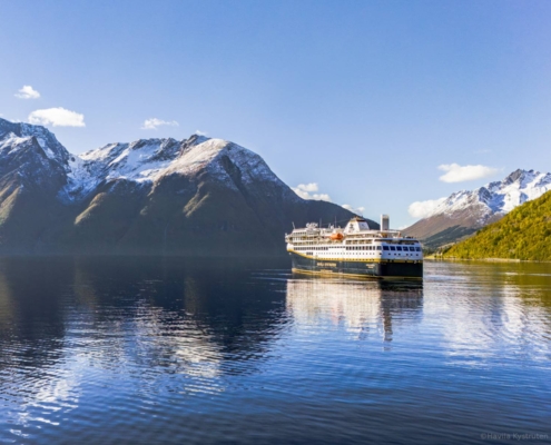 Crucero Havila navegando por el Hjørundfjord entre montañas escarpadas