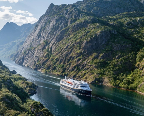 Crucero Havila navegando por el Trollfjord entre acantilados verdes