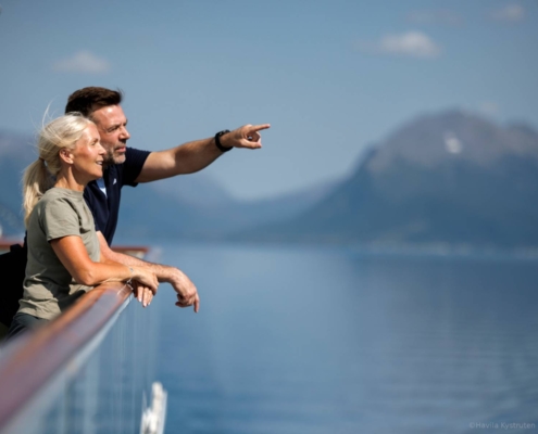 Pareja observando el paisaje desde la cubierta del crucero Havila en Tromsø
