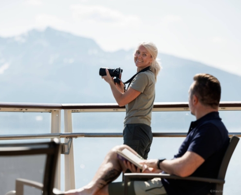 Pasajeros observando fiordos desde la cubierta del crucero Havila