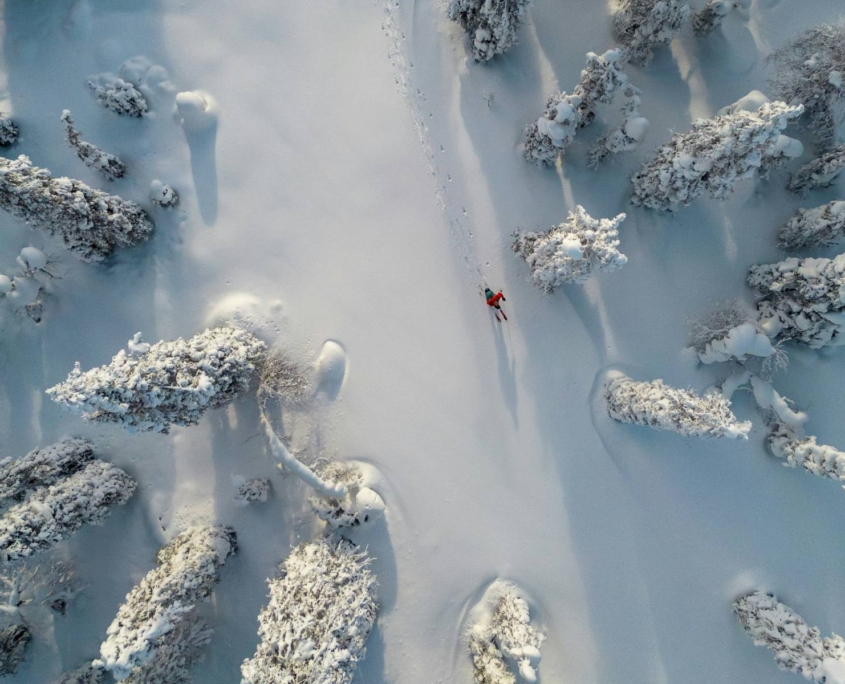 Persona caminando sola por paisaje invernal nevado con huellas en la nieve
