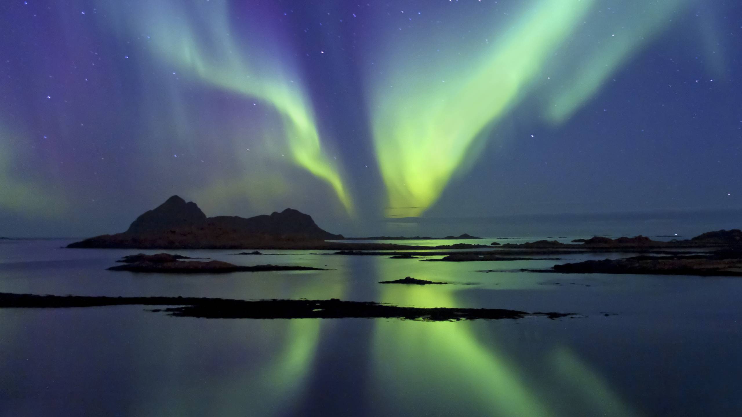 Auroras boreales reflejadas en lago helado bajo cielo nocturno, paisaje del norte