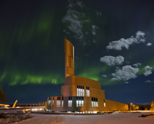 Auroras boreales verdes sobre la catedral iluminada de Alta, Noruega.
