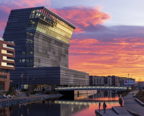 Museo Munch junto al canal bajo un cielo rosado y anaranjado en Oslo, Noruega.